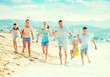 © JackF - Family with four kids happily running on beach