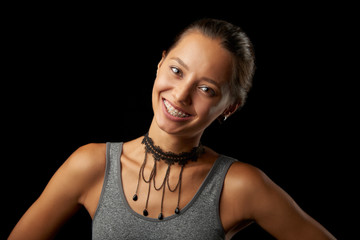 Girl with braces on black background