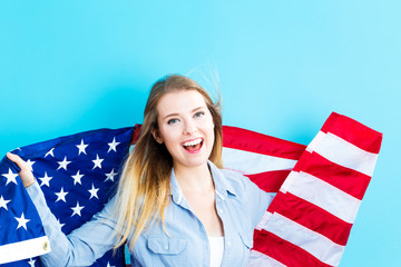 Wall Mural - Young traveling woman holding American flag