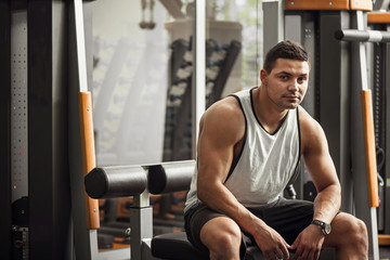 Wall Mural - Good looking professional sportsman sitting in a gym