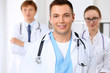 © rogerphoto - Cheerful smiling male doctor with medical staff at the hospital