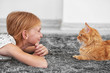 © Africa Studio - Beautiful little girl lying on floor with red fluffy cat