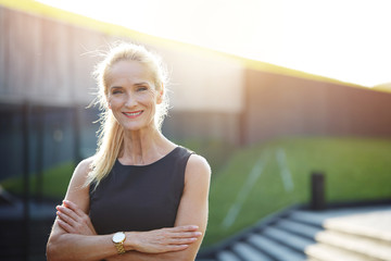 Happy businesswoman with crossed arms