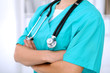 © rogerphoto - Female surgeon doctor is standing with arms crossed at hospital.  Physician  is ready to examine patient