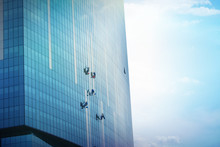 A Team Of Climbing Workers Clean The Windows On Skyscraper
