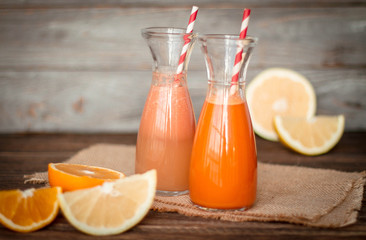 Fresh juice and smoothies with fruits on wooden background