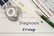 Diagnosis Croup. Stethoscope, electronic thermometer, patient blood test results lying on medical history, which is written diagnosis Croup. Concept for internal medicine, ENT