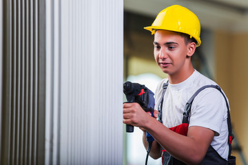 Wall Mural - Man drilling the wall with drill perforator