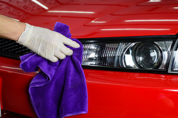 Wall Mural - Car detailing series : Closeup of hand cleaning red car paint