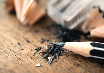 pencil with sharpening shavings, on wooden table..