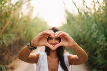 Happy Woman Making Heart Shape With Hands