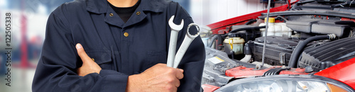 Mata magnetyczna Ręce mechanika samochodowego z kluczem w garażu.