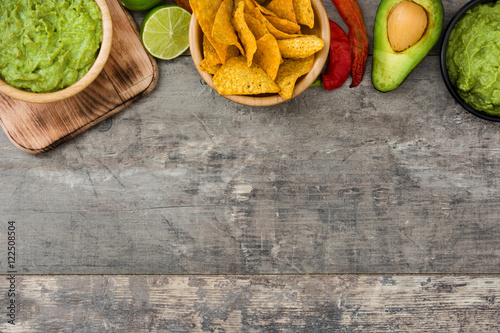 Fotografía Nachos, guacamole and ingredients on wooden background
