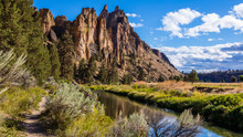 The River Is Flowing Among The Rocks. Colorful Canyon. Reflection Of The Yellow Rocks In The River. Amazing Landscape Of Yellow Sharp Cliffs. Smith Rock State Park, Oregon