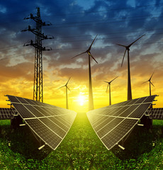 solar panels with wind turbines and electricity pylon at sunset. clean energy concept.