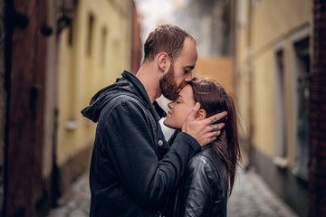 Wall Mural - Positive bearded male kissing cute brunette female.