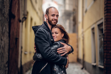 Wall Mural - Positive bearded male hugging cute brunette female.