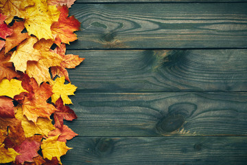 Wall Mural - Wooden background with autumn leaves