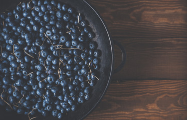 Wall Mural - Blueberries on vintage wooden black background top view, healthy food on dark table mockup, berry for smoothie isolated on rustic country board, fresh nutrition closeup, copy space for text design