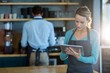 Waitress using digital tablet at counter