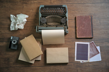 Wall Mural - Retro typewriter with camera and photos on wooden background