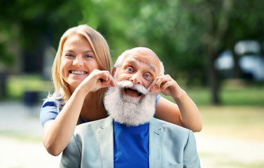 Grandfather and granddaughter sitting in a park