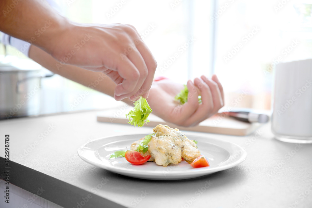 Young handsome chef cook preparing food in kitchen