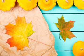 Wall Mural - Pumpkins and maple leaves on a table. Top view