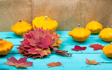 Wall Mural - Pumpkins and maple leaves on a table