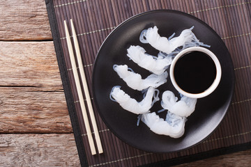 Wall Mural - Shirataki Noodles with soy sauce and chopsticks close-up on a plate. Horizontal top view