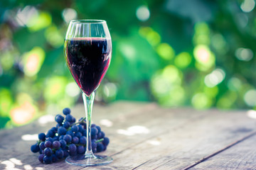 Glass with red wine on the wooden table. Shallow depth of field.