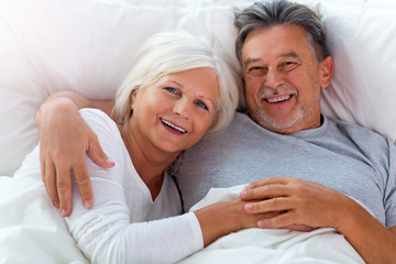 Wall Mural - Senior couple lying in bed together
