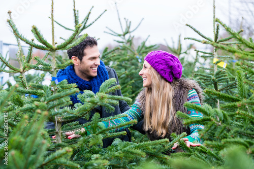 Fotografía Frau und Mann kaufen Weihnachtsbaum auf Markt