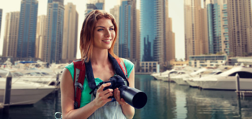 Canvas Print - woman with backpack and camera over dubai city