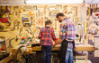 © Syda Productions - father and little son with wood plank at workshop