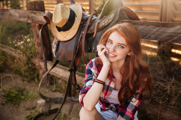 Wall Mural - Close up portrait of a happy beautiful redhead cowgirl resting