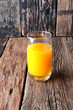 Glass of orange juice on wooden background. Copyspace