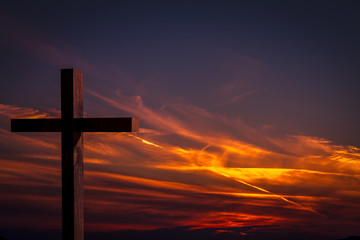 Wall Mural -     Jesus Christ cross. Christian wooden cross on a background with dramatic lighting, colorful sunset, twilight and orange -  purple clouds and sky.  Easter, resurrection,Good Friday concept