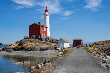 White Lighthouse on Rock Strewn Beach With Path