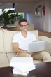 © sepy - Working at home. Shot of a handsome middle aged man using his laptop while sitting at sofa in living room.