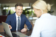 © sepy - Successful business consultation. Portrait of investment advisor businesswoman sitting at office in front of laptop and consulting with executive professional business man