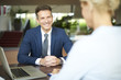 © sepy - Successful business consultation. Portrait of investment advisor businesswoman sitting at office in front of laptop and consulting with executive professional business man