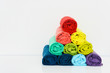 stack of colorful t-shirt rolled up on white background, copy space