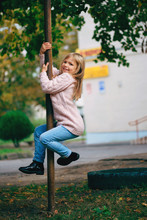 Young Happy Girl Climbing The Pole