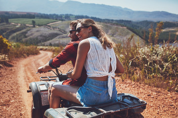 Young happy couple cruising on a quad vehicle