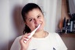 © dojo666 - Young woman brushes teeth in bathroom an electric brush