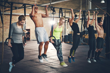 Adults doing chin ups for cross fit training