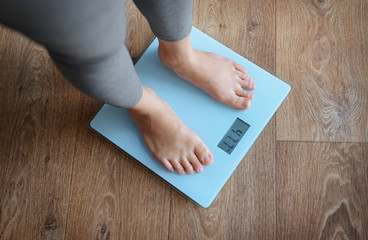 Canvas Print - Female bare feet standing on a scales