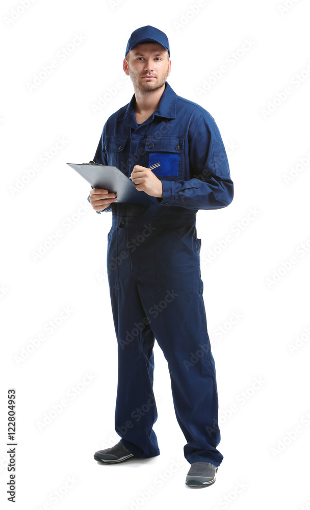 Young mechanic in uniform with a clipboard and pen, isolated on white