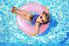 Little Girl With Pink Rubber Ring In Swimming Pool